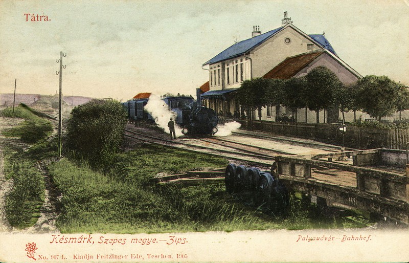 Stará výpravná železničná stanica na dobovej kolorovanej pohľadnici, spoza železničných koľají.